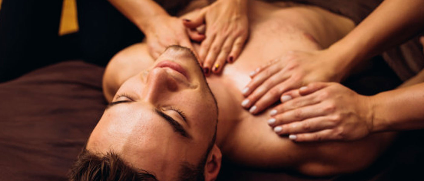 Imagem de duas terapeutas realizando uma massagem Four Hands em um cliente